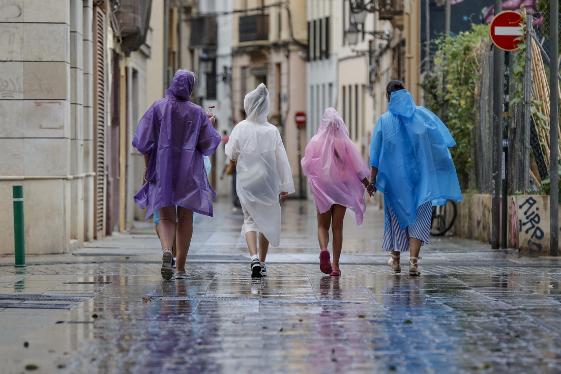 Varias personas caminan bajo la lluvia por una calle del centro deVal&egrave;ncia. EFE/Manuel Bruque