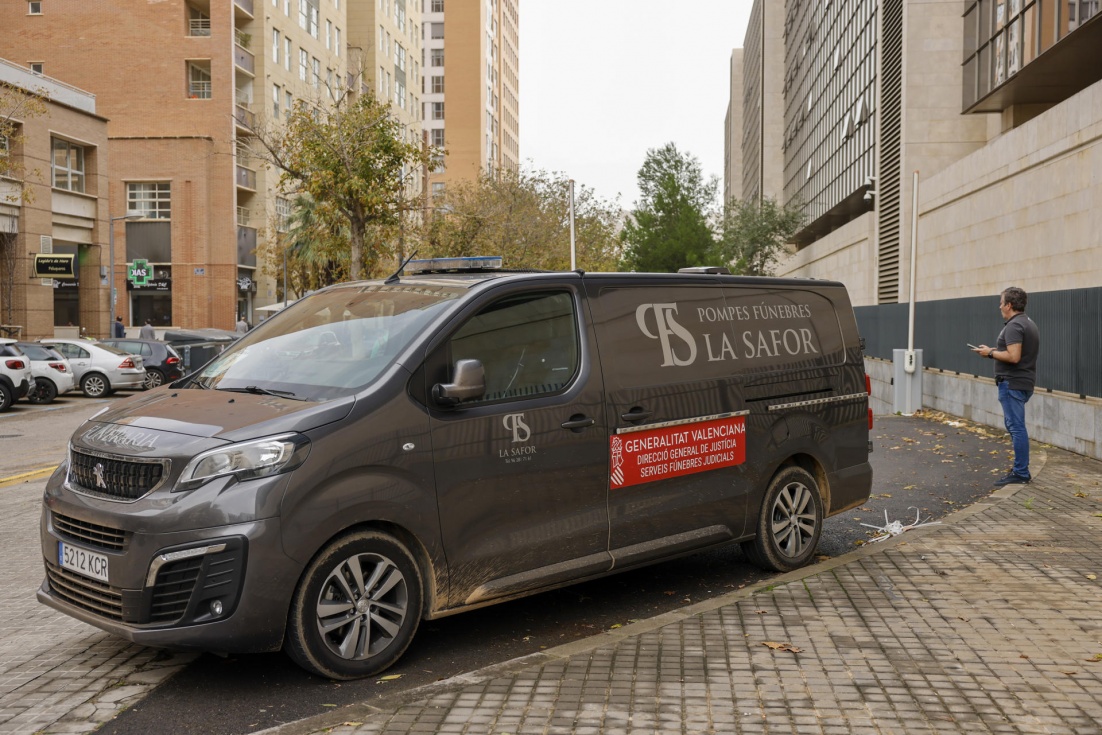 Una persona aguarda junto al veh&iacute;culo del ret&eacute;n f&uacute;nebre estacionado en la Ciudad de la Justicia donde se encuentra el instituto de medicina legal. EFE/Ana Escobar