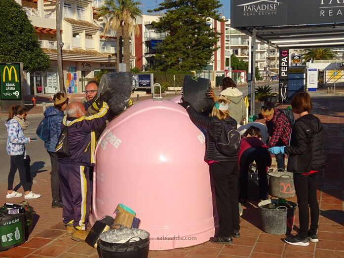 Voluntarios de Xàbia llevan a los contenedores rosas restos de vidrios recuperados de un antiguo vertedero del río