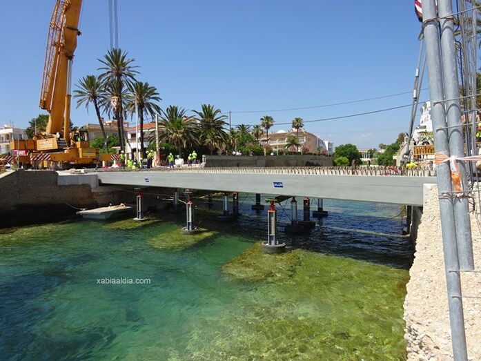 Dos enormes grúas colocan las vigas del puente de Triana