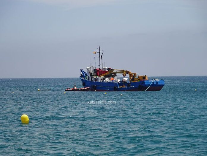 Una gran barcaza repara el emisario de la playa del Arenal