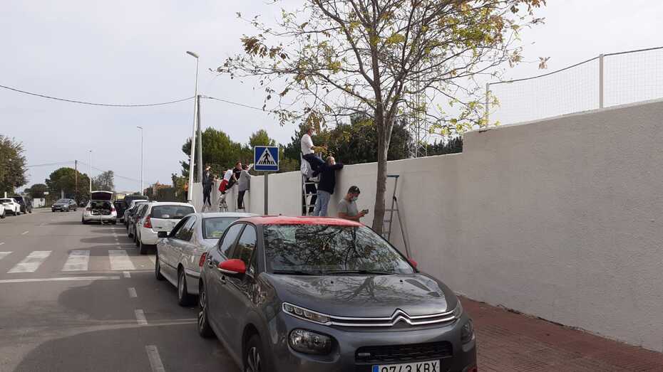 Fotonoticia: Padres y madres subidos a escaleras para ver los partidos de sus hijos