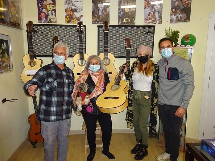 María Ferrer entrega la guitarra Bros a la ganadora de la rifa solidaria